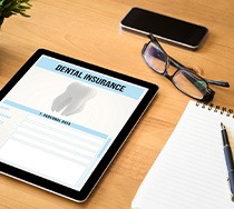 Dental insurance form on desktop with notepad